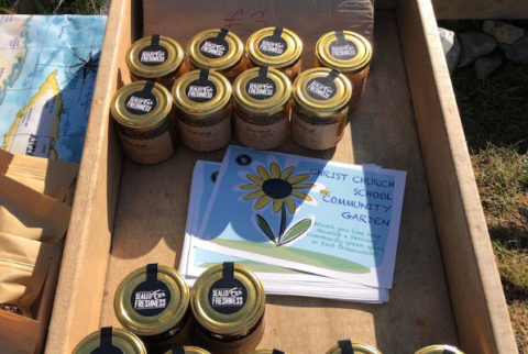 A wooden box with small pots of honey and leaflets