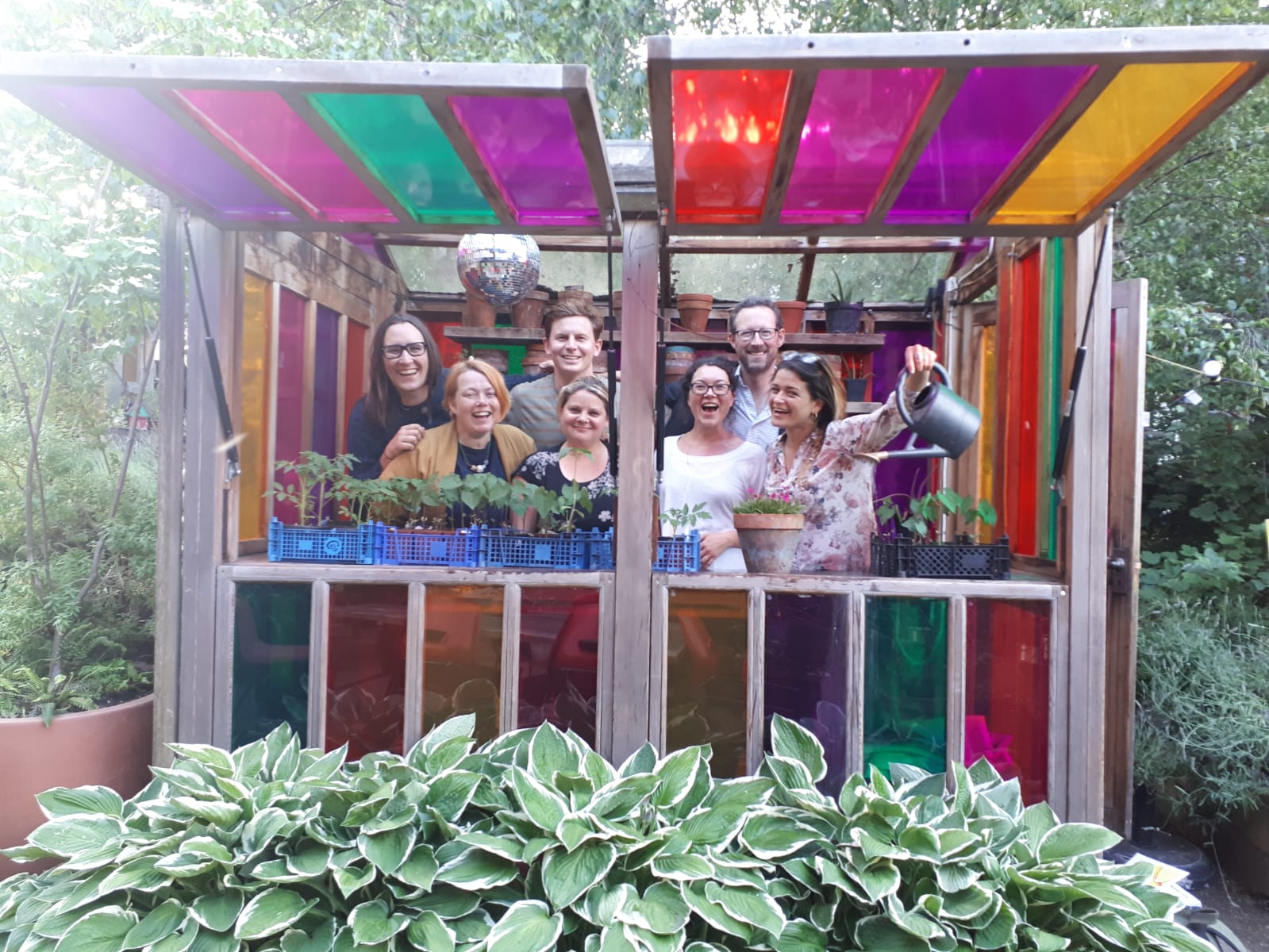 The ActionFunder team are all smiling in a colourful shed
